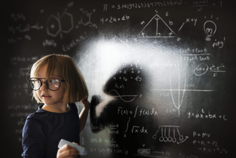 Young girl with glasses studying science and math equations.