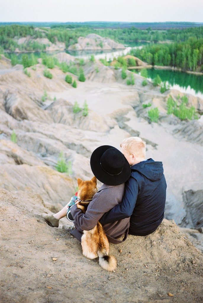 a man and a dog sitting on a hill