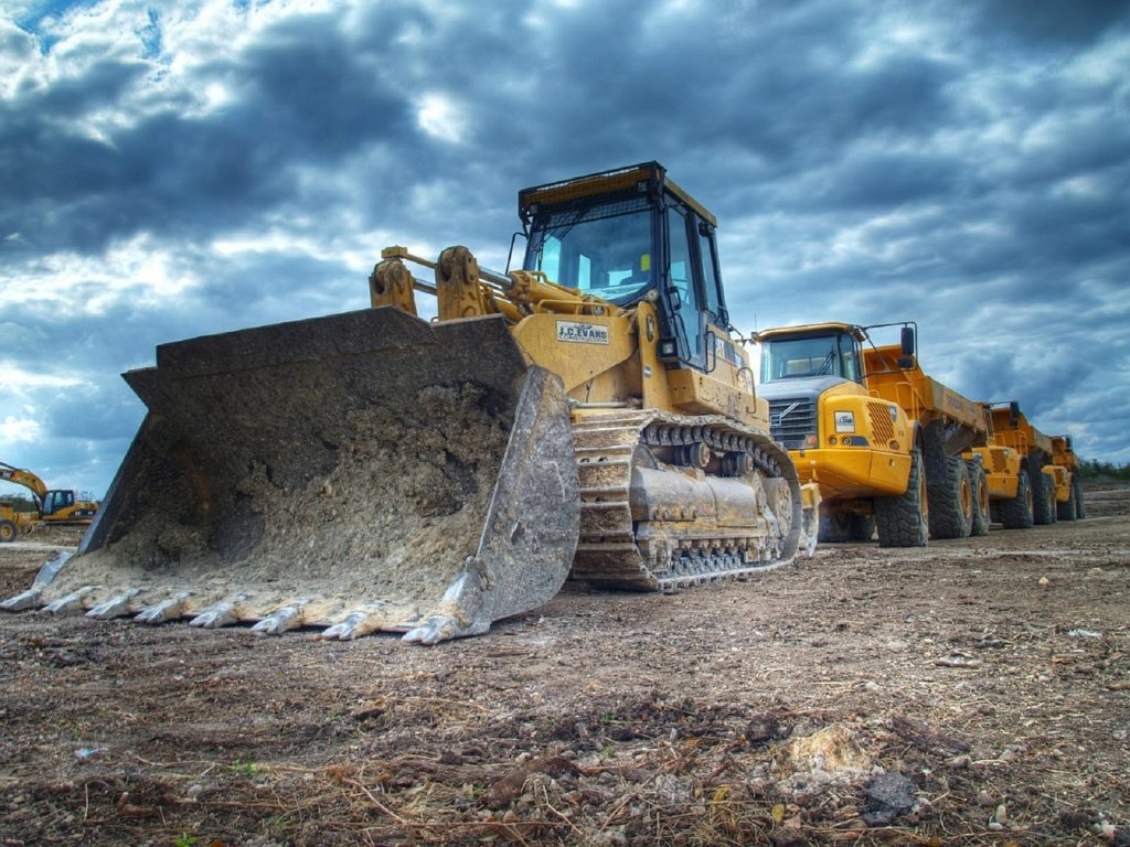 a construction site with a few large yellow machines