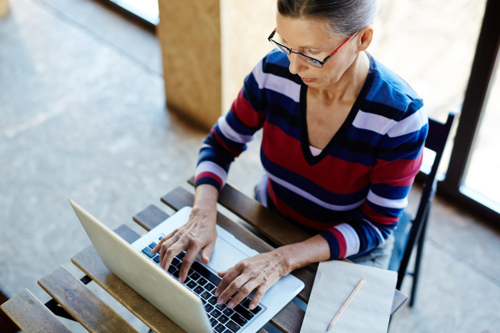 a person sitting in a chair using a laptop